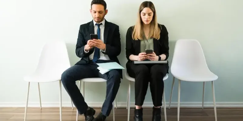 professional-business-woman-man-looking-their-smartphones-texting-while-waiting-job-interview-while-sitting-recruitment-office_662251-297